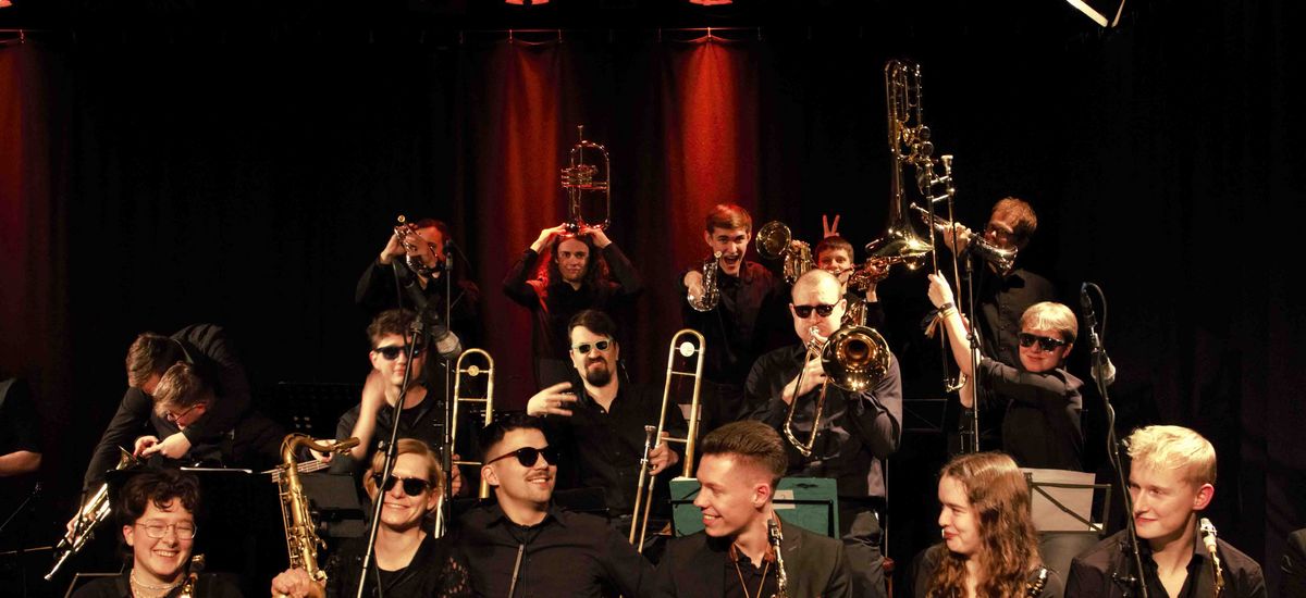Die Band trägt Sonnenbrillen und albert herum.