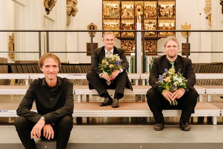 Die drei Dirigenten David Timm (Leipzig), Fabian Pasewald (Jena) und Jens Lorenz (Halle) nach dem Konzert auf der Bühne sitzend