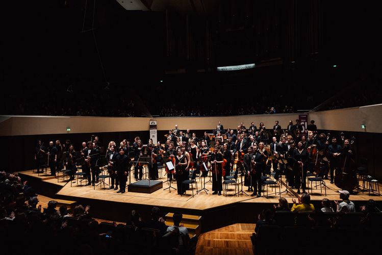 Ein Orchester steht während des Applauses auf der Bühne des Großen Saals des Gewandhauses.