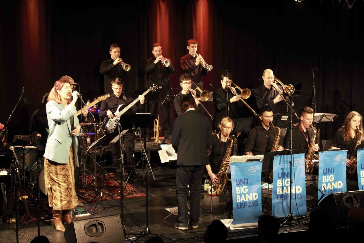 zur Vergrößerungsansicht des Bildes: Eine Sängerin sing mit der Band zusammen.
