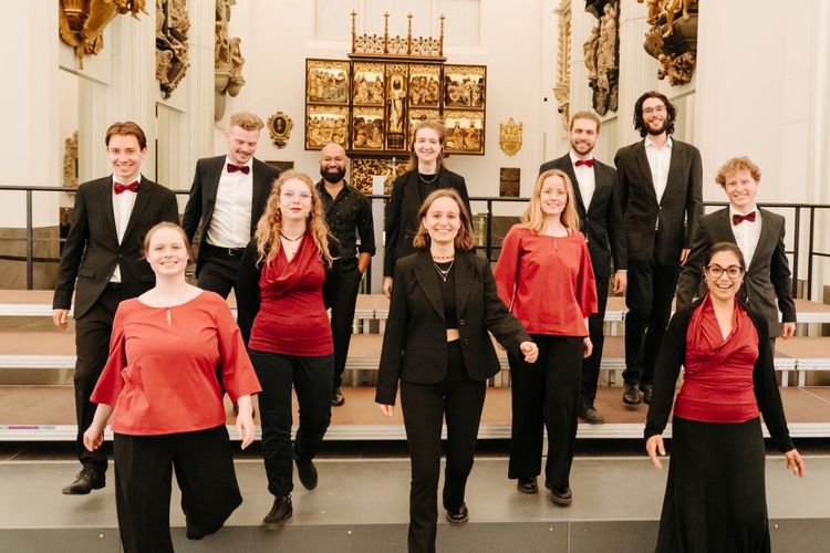 Gruppenbild mit jeweils zwei Sängerinnen und zwei Sängern der drei Chöre nach dem Konzert auf der Bühne